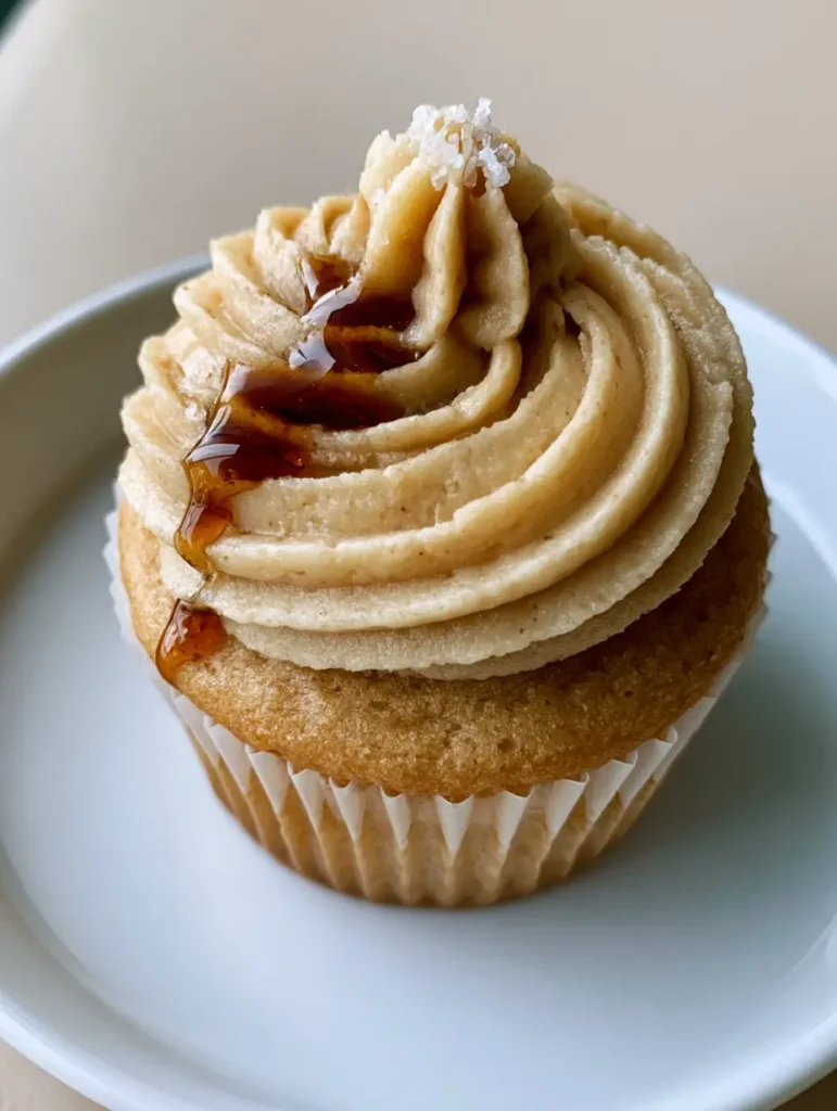 Detailed shot of the maple syrup drip and flaky sea salt on the tan-colored Maple Buttercream Frosting.