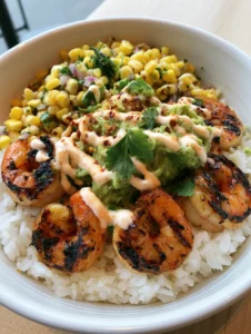 Close up of a Grilled Shrimp Bowl on a wooden table with visible grill marks on the shrimp and vibrant corn kernels.