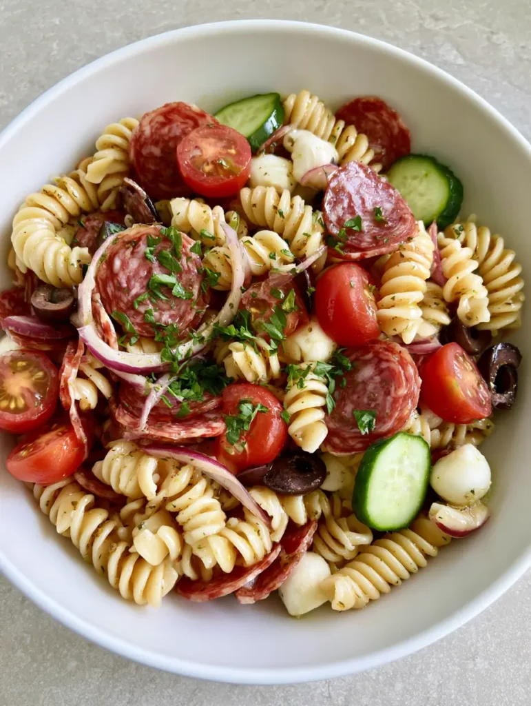 Detailed view of glossy rotini and marbled salami slices in a High-Protein Italian Pasta Salad.