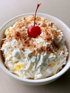 Close-up of Hawaiian Pineapple Coconut Fluff showing thick whipped folds, mini marshmallows, and yellow pineapple bits.