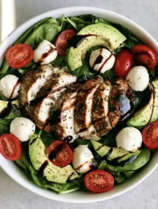 Top-down view of Baked Chicken Salad with spinach, cherry tomatoes, and pearline mozzarella.