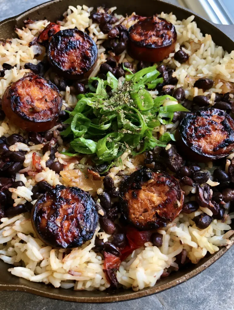 One-Pot Black Beans and Rice with Sausage: The Ultimate 30-Minute Comfort Meal 1 Close up shot of caramelized sausage rounds and red bell peppers folded into fluffy rice and black beans.