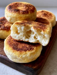 Close up of Homemade English Muffins showing the airy porous bread interior and toasted exterior.