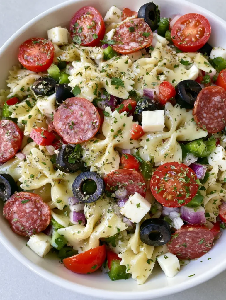 Italian Bow Tie Pasta Salad with fresh parsley and dried oregano garnish.