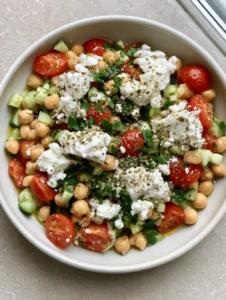 Close up of High-Protein Chickpea Salad showing glistening lemon-oil dressing and large chunks of feta cheese.