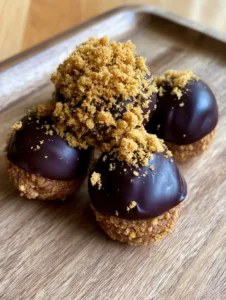 Close-up of a dense, moist gingerbread truffle center encased in a uniform dark chocolate shell with a satin sheen. (Gingerbread Truffles Recipe)