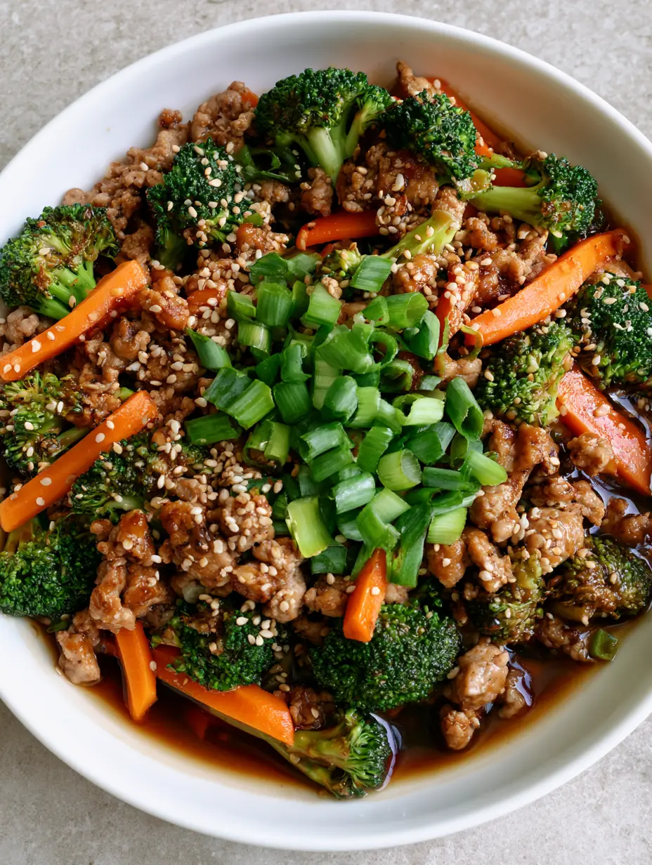 Close-up of seared ground turkey crumbles and emerald broccoli in a glossy dark soy sauce. (Ground Turkey Stir Fry)