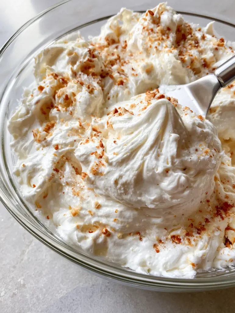 Detailed view of Marshmallow Buttercream Frosting topped with toasted marshmallow bits and fine sugar crystals.