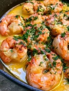 Close-up of seared jumbo Garlic Butter Shrimp glistening in a golden butter sauce.